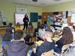 Alumnos atienden a la profesora durante una clase