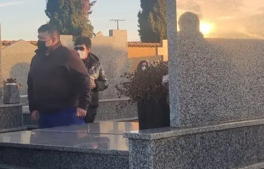 Varias personas asisten a un entierro