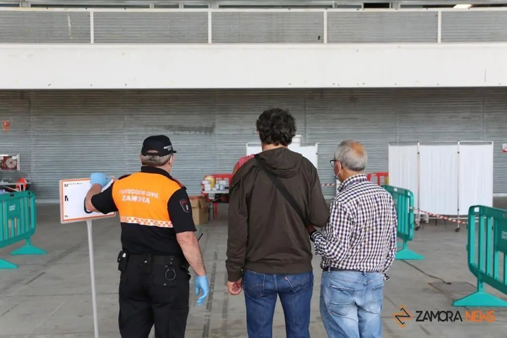 Protección Civil orienta a unos ciudadanos en el vacunódromo de IFEZA