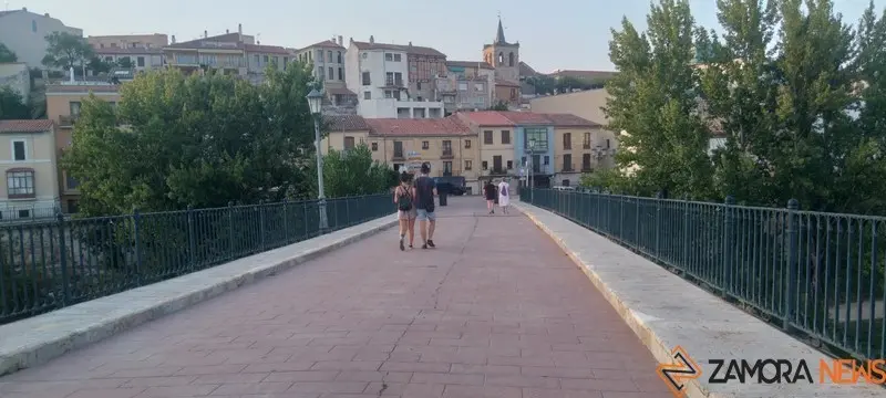Viandantes de paseo por el puente de piedra