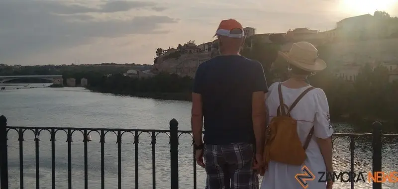Turistas contemplan la ciudad desde el Puente de Piedra