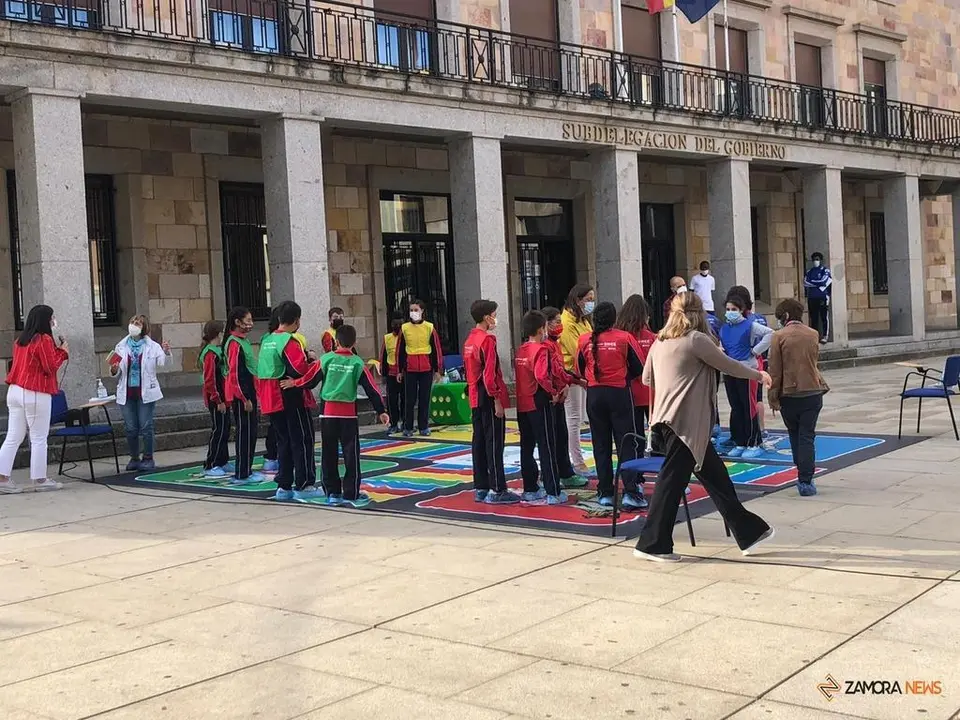 Varios menores participando en el juego el parchís de la inclusión en la plaza de la Constitución