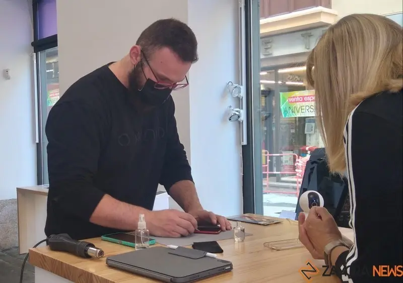 Kevin Hetzel atiende a una clienta en su tienda