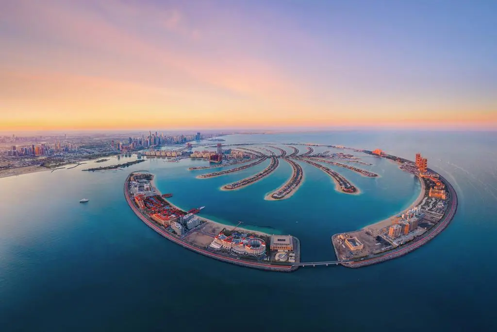Aerial view of The Palm Jumeirah Island, Dubai Downtown skyline, United Arab Emirates or UAE. Financial district and business area in smart urban city. Skyscraper and high-rise buildings at sunset. (Aerial view of The Palm Jumeirah Island, Dubai Downt