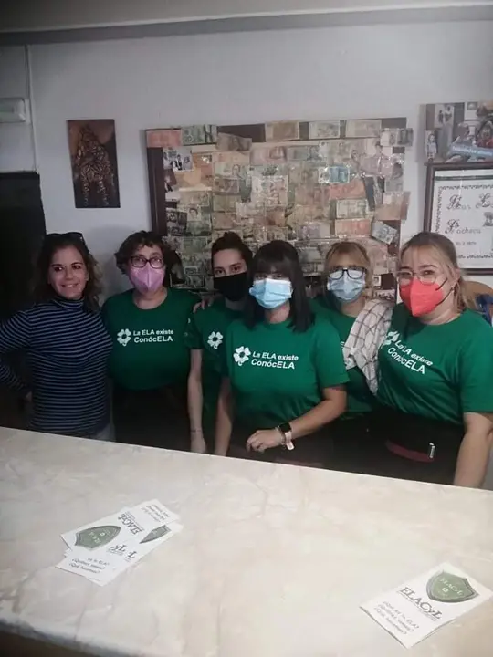 La dueña y empleadas del bar con las camisetas contra la ELA