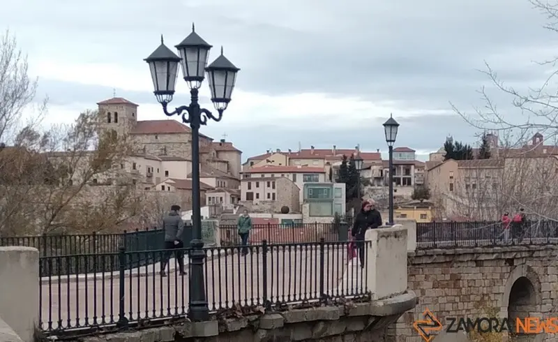 Gente paseando por el puente de piedra