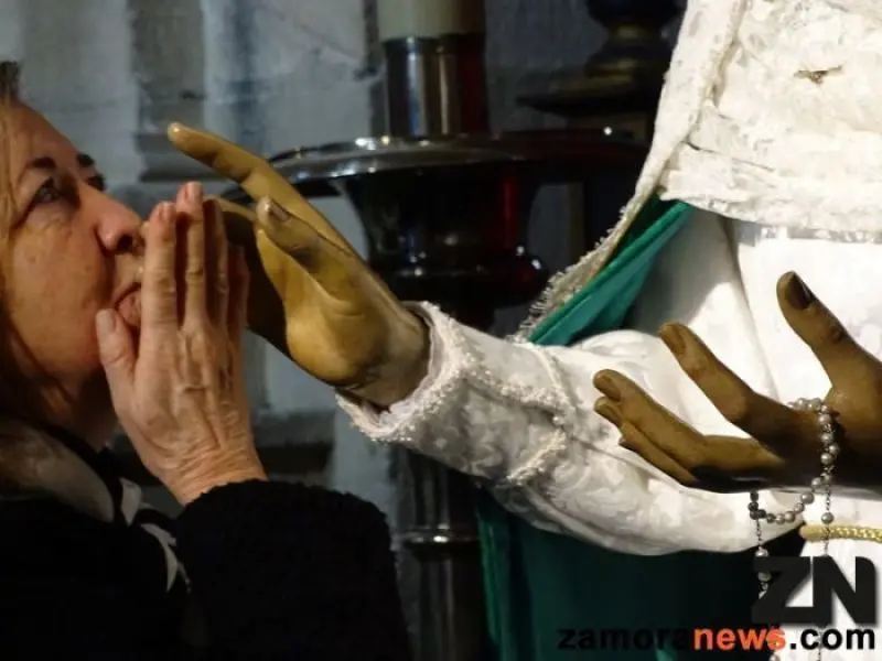 Una feligresa besa la mano de la Virgen de la Esperanza.