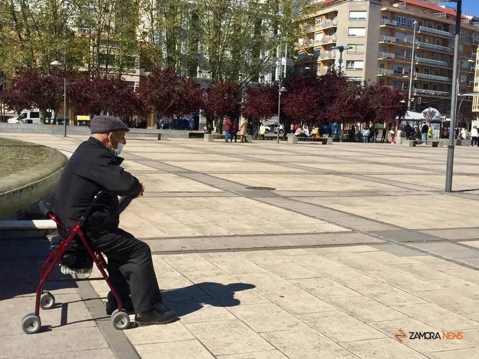 Una persona mayor descansa junto a la fuente de La Marina