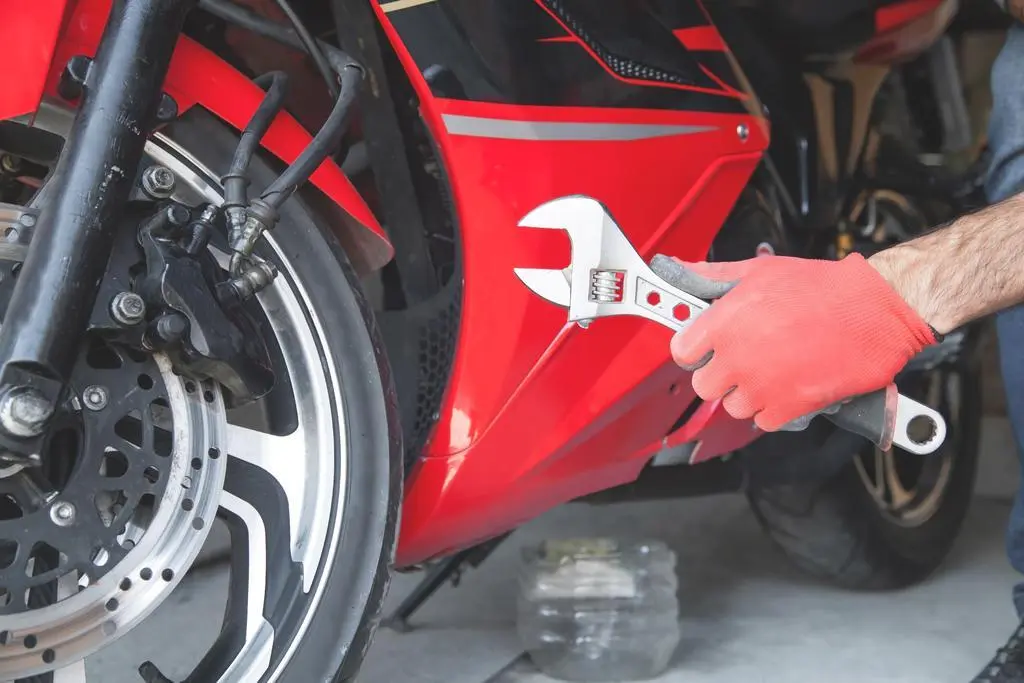 Mechanic using a wrench on a motorcycle. Garage. Work