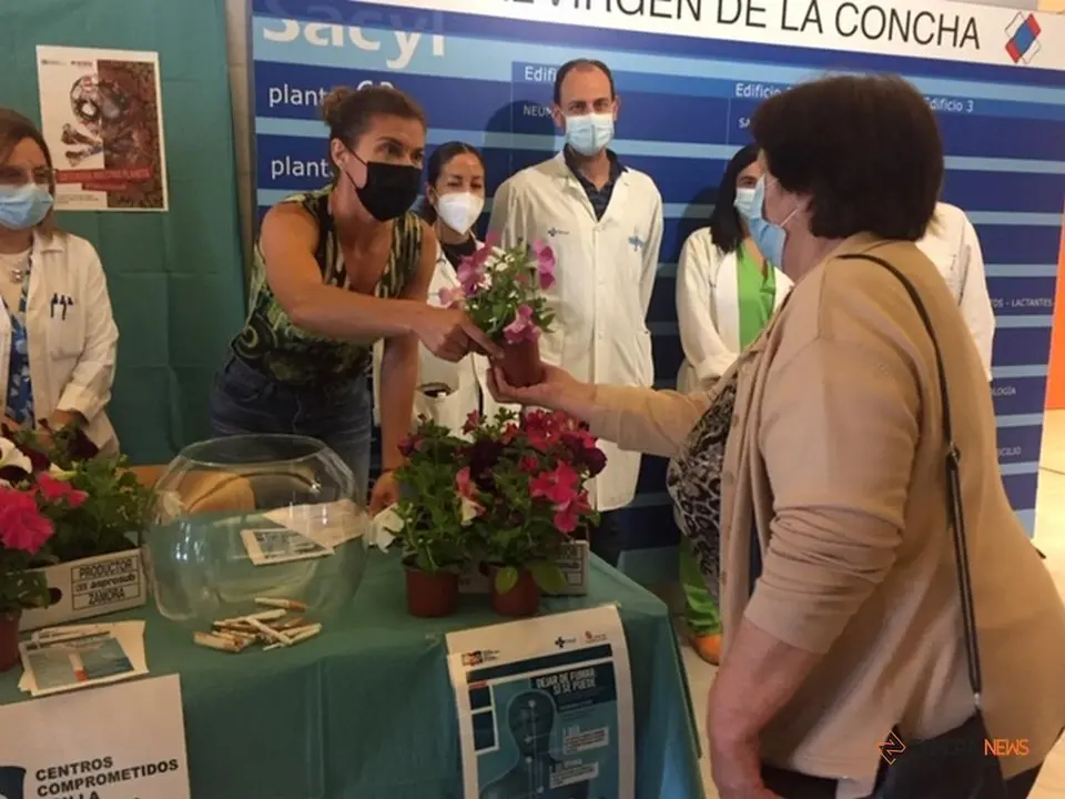 La delegada territorial de la Junta en Zamora, Clara San Damián, entrega un geranio a cambio de un cigarrillo con motivo del Día Mundial Sin Tabaco