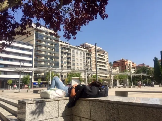Un paseante descansando en la plaza de La Marina
