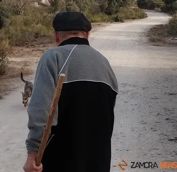 Una persona mayor camina por un pueblo