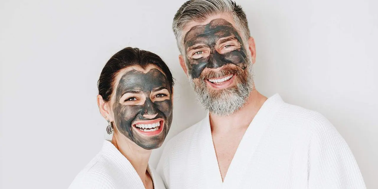 Happy couple wearing a charcoal mask