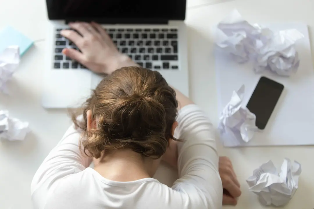 Top view portrait of a woman lying at the desk near the laptop. Education, business concept photo. Lifestyle