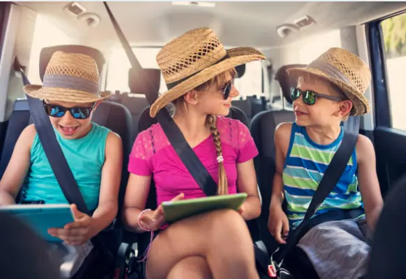 Niños utilizando una tableta durante un viaje. Fotografía de archivo