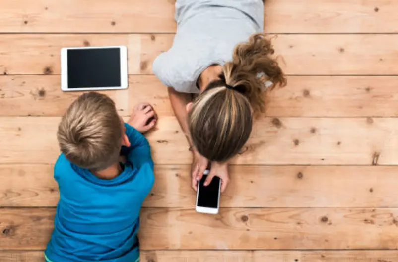 Fotografía de archivo de niños jugando con dispositivos electrónicos