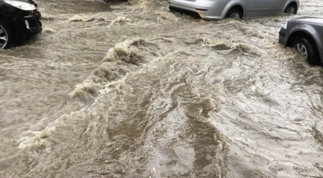 Coche circulando durante una inundación