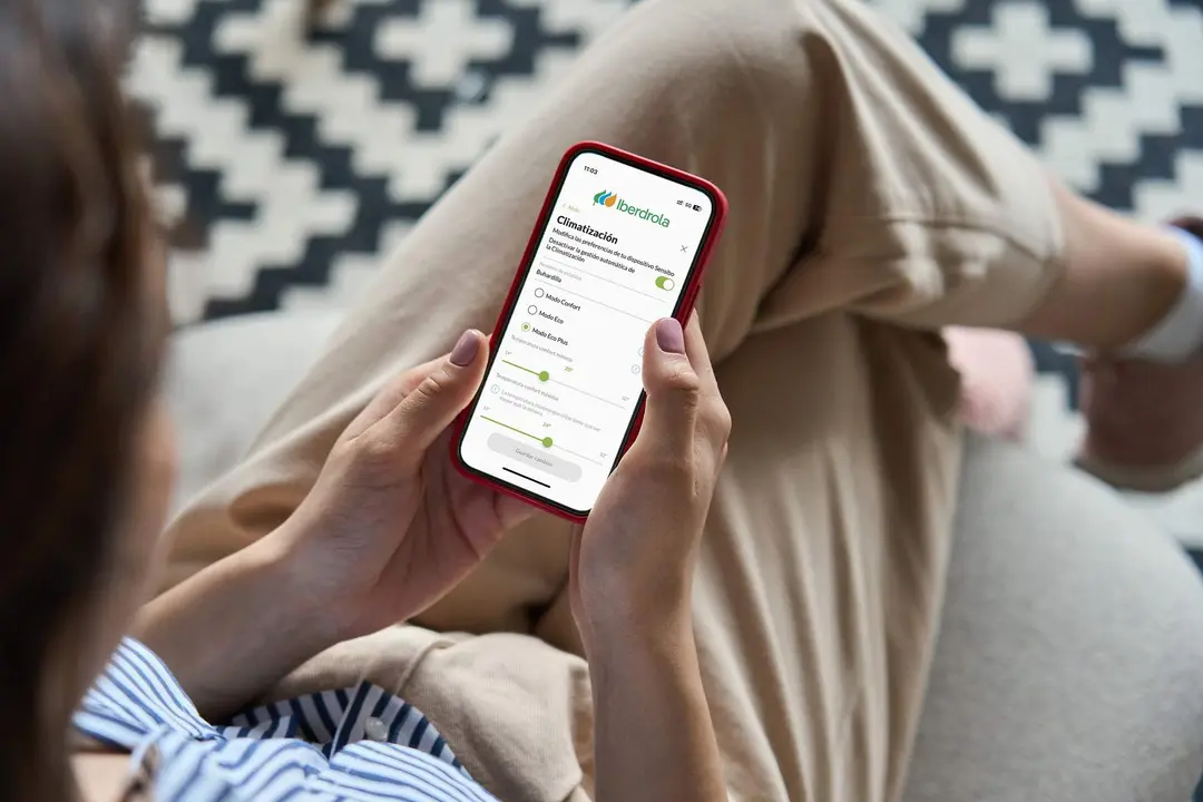 Young woman or teen girl hands holding mobile smart phone with mockup white blank display, empty screen at home. Shopping, delivery apps, social media applications ads, over shoulder close up view.