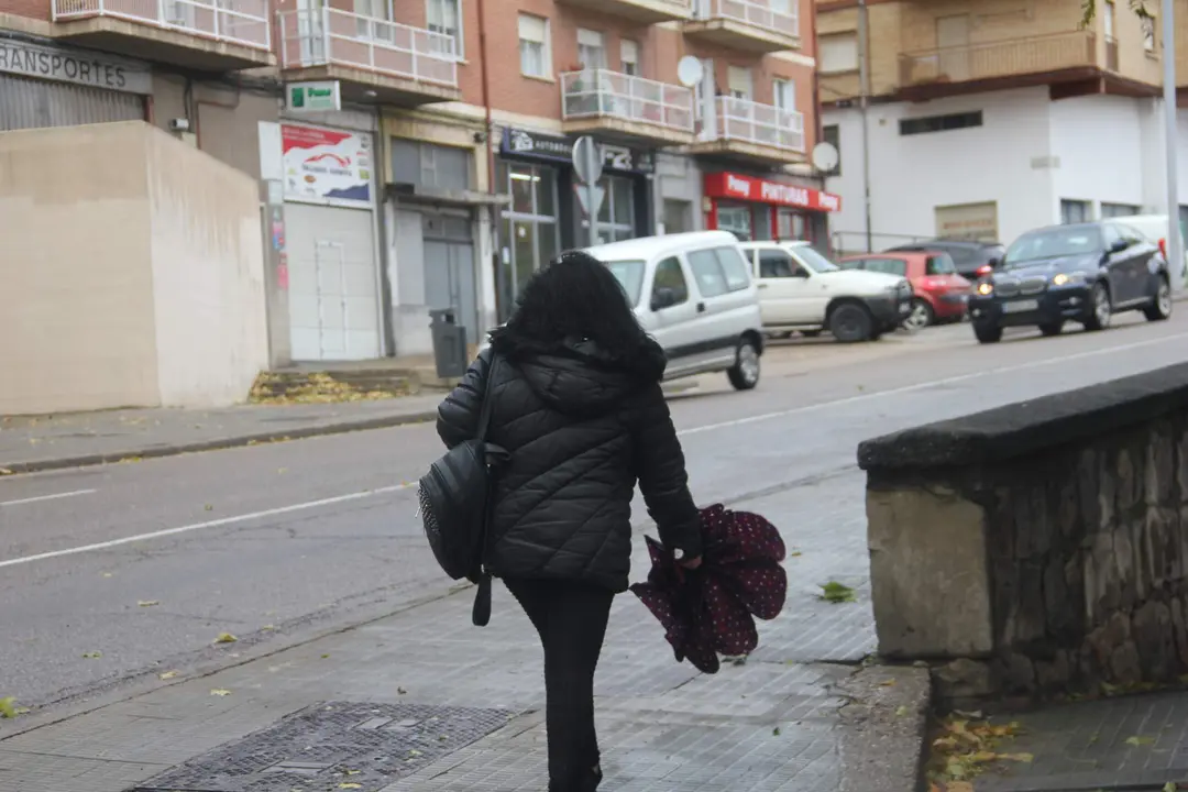 Una mujer pasea con el paraguas en la mano por Zamora