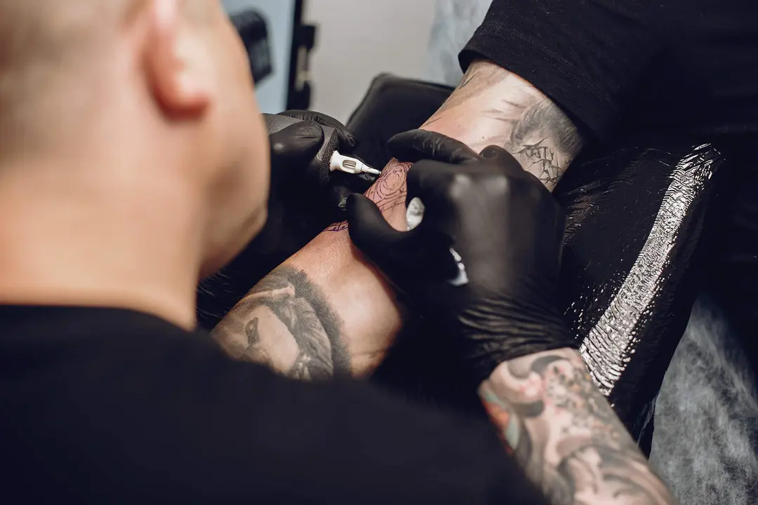 Man in a tattoo salon. Guy working. Man create a new tattoo