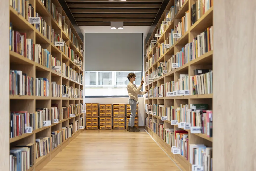 Mujer en una biblioteca. Imagen de archivo