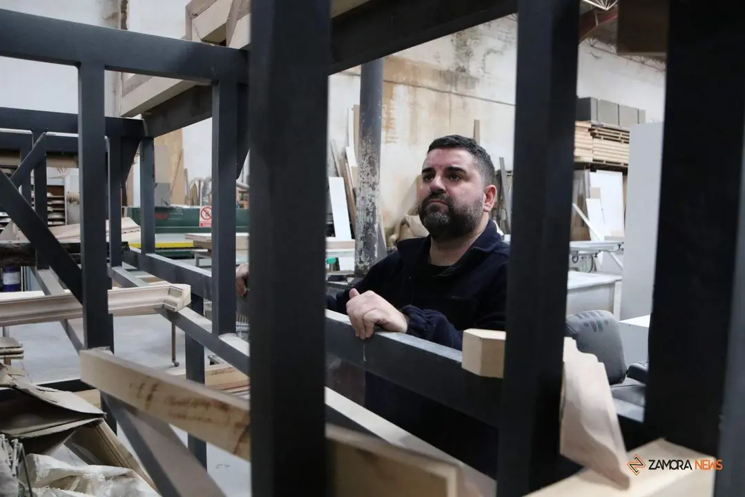 El tallista zamorano José Ángel Domínguez Ramos junto a la estructura que esconderá la nueva mesa de la virgen Dolorosa. Fotografía: Marcos Vicente