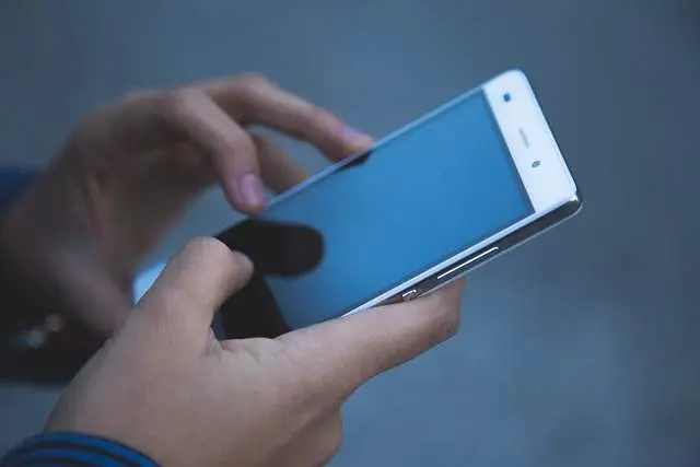 Una persona utiliza su teléfono móvil. Imagen de archivo