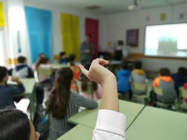 Un alumno levanta la mano en clase. Imagen de archivo