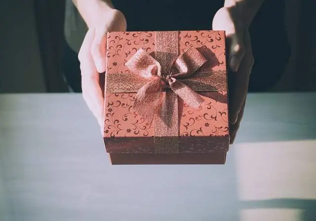 Una persona entrega un regalo. Imagen de archivo