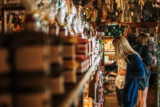 Una mujer comprando souvenirs en un negocio. Imagen de archivo