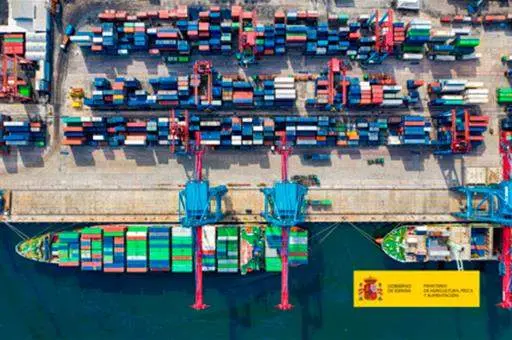 Imagen aérea de barco en puerto cargando contenedores