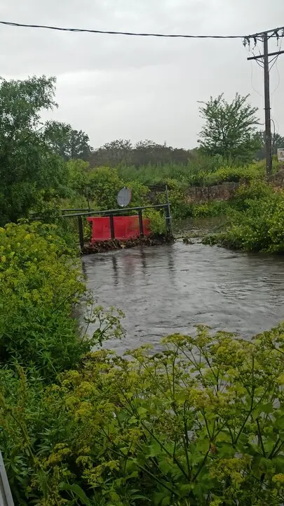 El caudal del arroyo supera la altura del puente del Camino Gijón