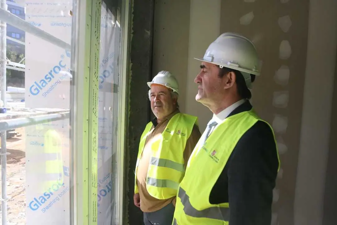 Alcalde y consejro en una de las estancias de la vivienda
