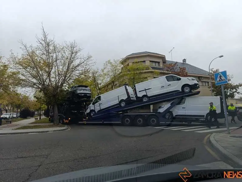 un camión portacoches queda encajado entre árboles_2