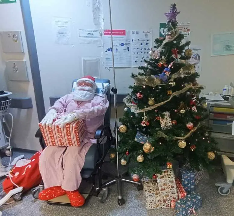 Papa Noel en sillón y árbol de Navidad