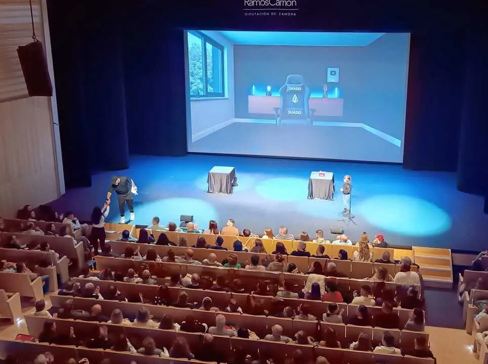 El mago con una ni&ntilde;a en el escenario interact&uacute;a con una espectadora