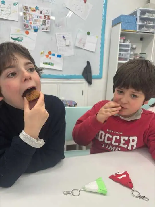 Dos alumnos, hermanos, comen las aceitadas elaboradas por ellos mismos