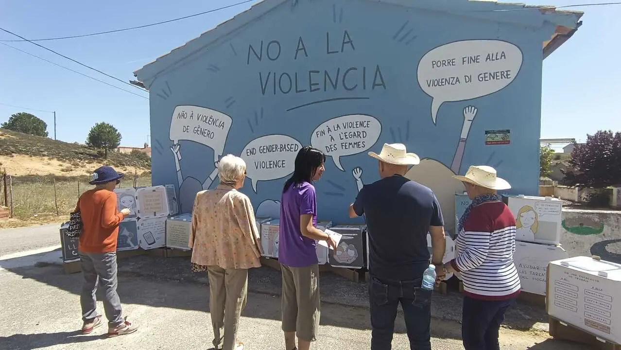 Vecinos con Raquel Pascual en la exposici&oacute;n itinerante sobre el mural contra la violencia de g&eacute;nero