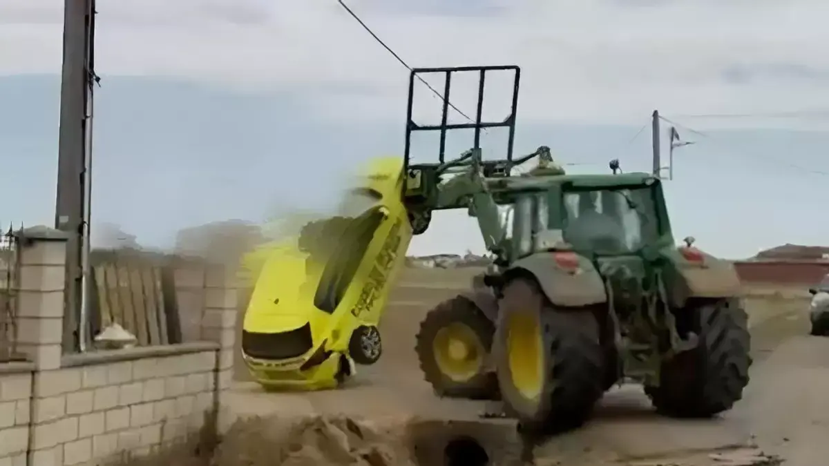 Imagen del momento en que el tractor arremete contra el coche de la empresa de cobros, volc&aacute;ndolo