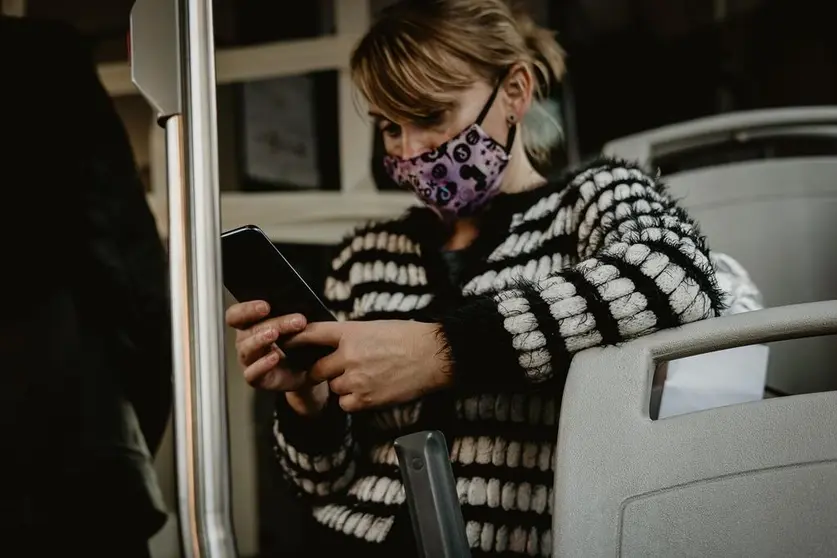 Una joven utilizando una masacrilla de tela en un autobús urbano