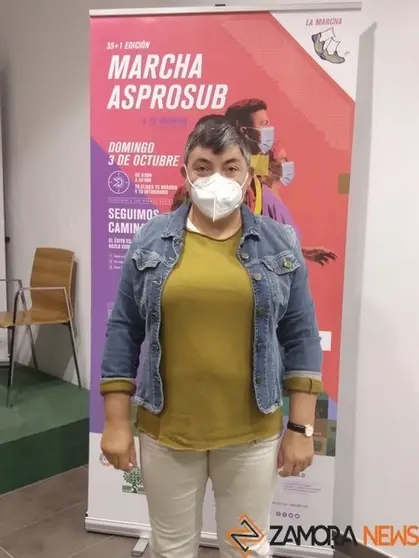 Elena Hernández ante el cartel de la Marcha de Asprosub