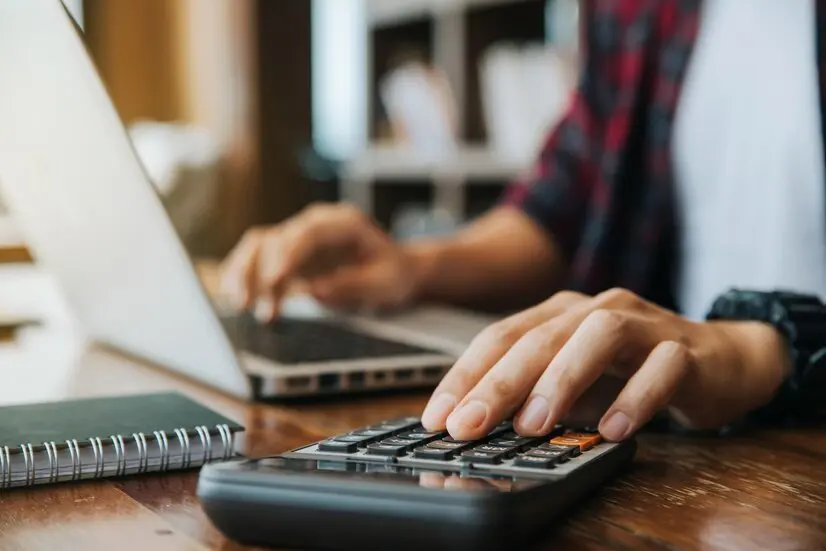 hombre-manos-usando-calculadora-computadora-portatil-calcular-papel-financiero_38391-564