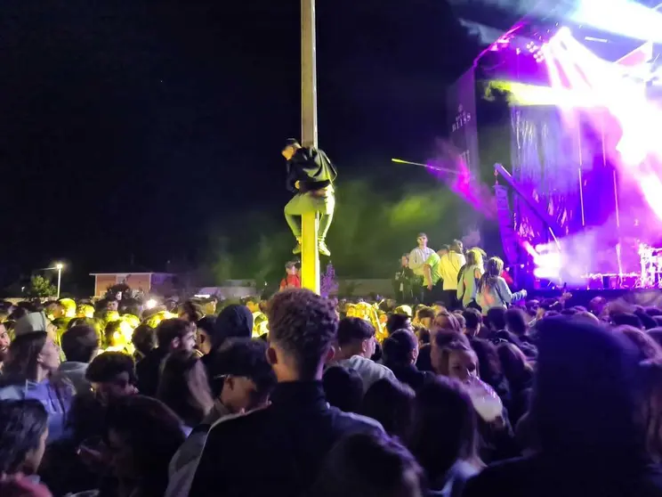 Un joven encarado a una farola durante una fiesta