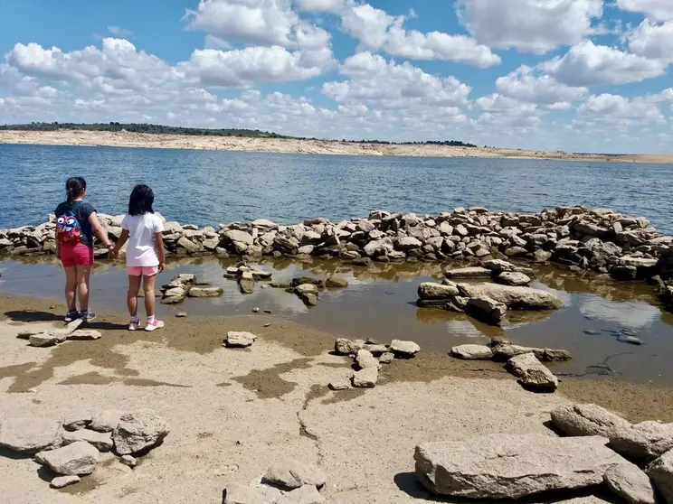 Lucía de pequeña sobre los restos visibles de Argusino, ante la bajada del nivel del embalse