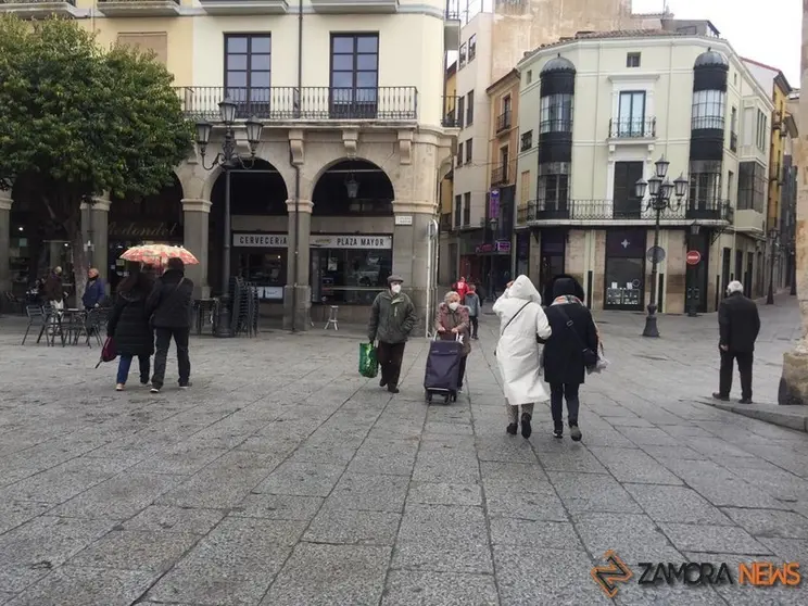 Viandantes bajo la lluvia en la Plaza Mayor de Zamora