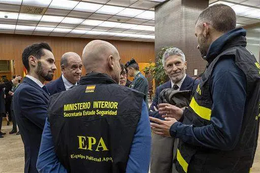 El ministro del Interior, Fernando Grande-Marlaska, charlando con miembros del Equipo Policial de Apoyo (EPA), en el aeropuerto Adolfo Suárez Madrid-Barajas, antes de la partida del EPA hacia Ucrania.