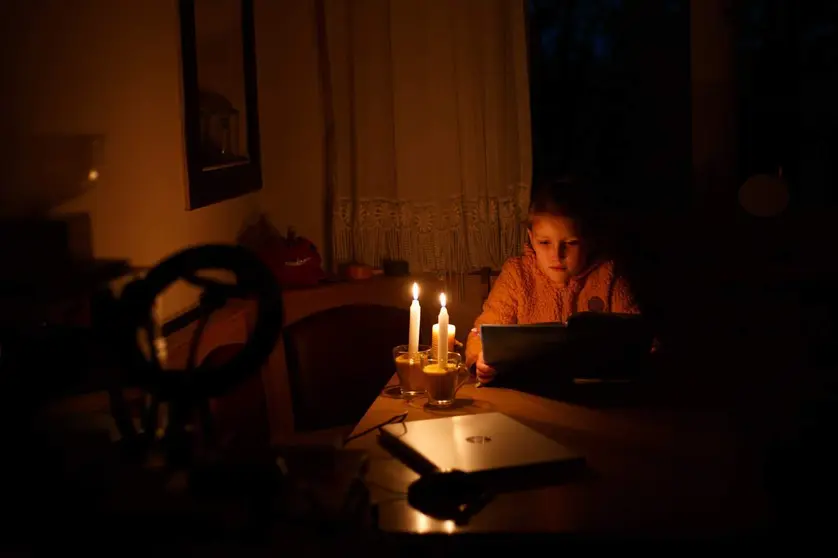 Menor ucraniana leyendo a la luz de las velas. Fotografía: Embajada de Ucrania en el Reino de España