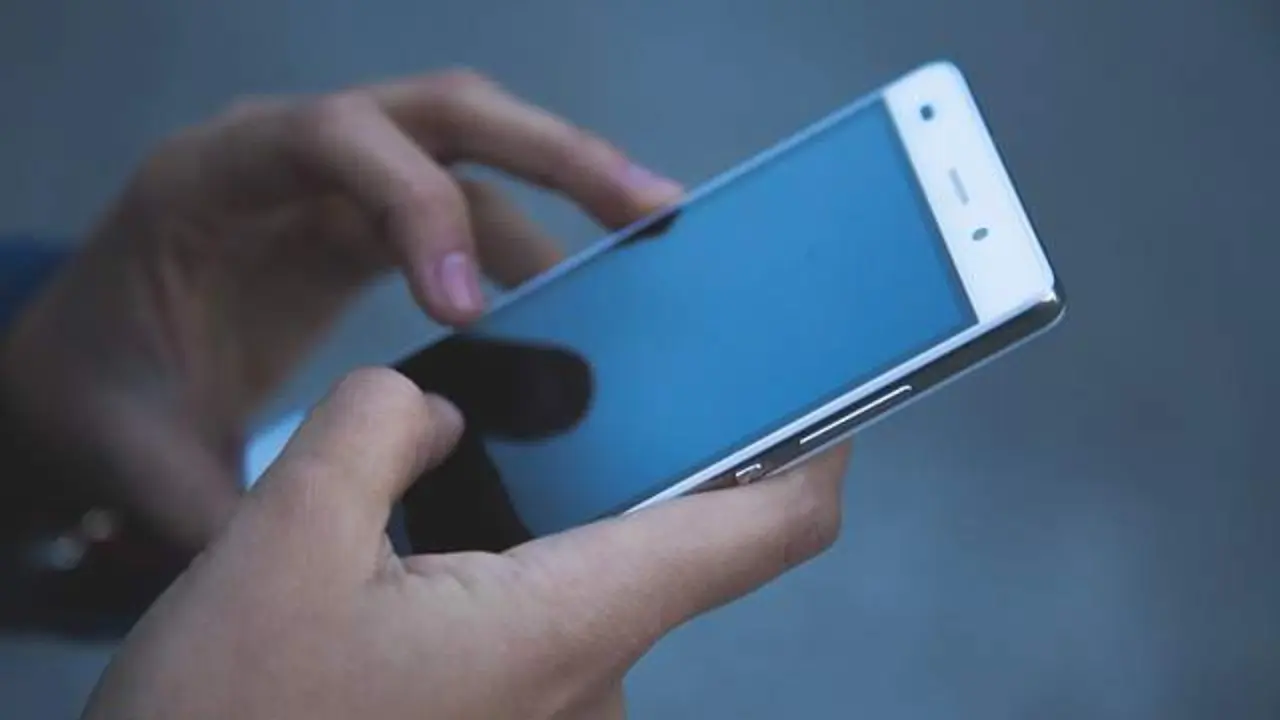 Una persona utiliza su tel&eacute;fono m&oacute;vil. Imagen de archivo