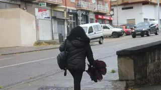 Una mujer pasea con el paraguas en la mano por Zamora