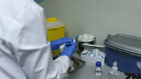 Un sanitario prepara una vacuna